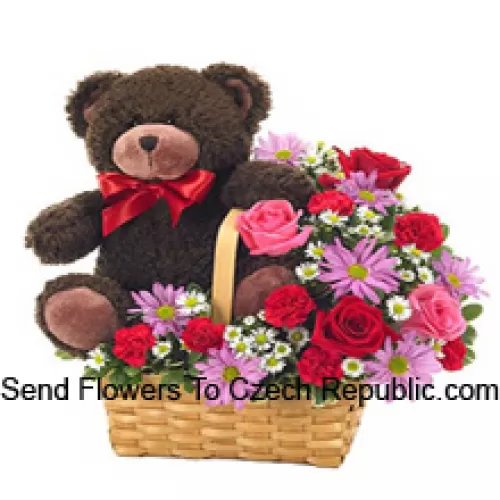 Un beau panier composé de roses rouges et roses, de œillets rouges et d'autres fleurs violettes assorties, accompagné d'un mignon ours en peluche de 14 pouces de hauteur