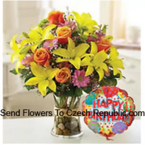 Tulipes jaunes, roses oranges et autres fleurs assorties arrangées parfaitement dans un vase en verre accompagné d'un ballon d'anniversaire