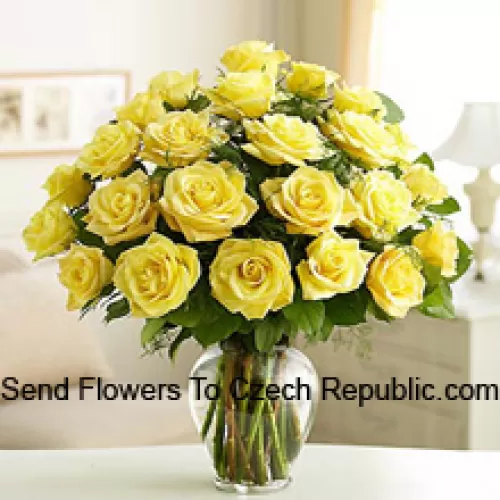 25 Yellow Roses With Some Ferns In A Glass Vase